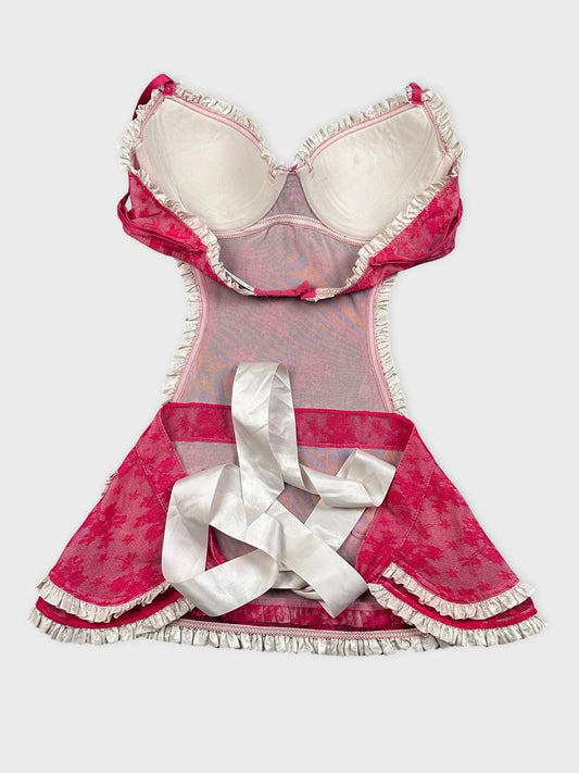 Back view of a pink vintage dress with lace trim and ribbon detail.