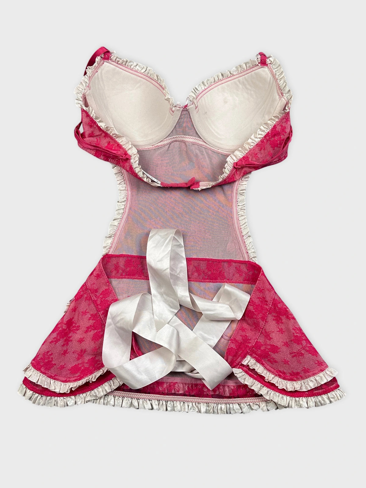 Back view of a pink vintage dress with lace trim and ribbon detail.