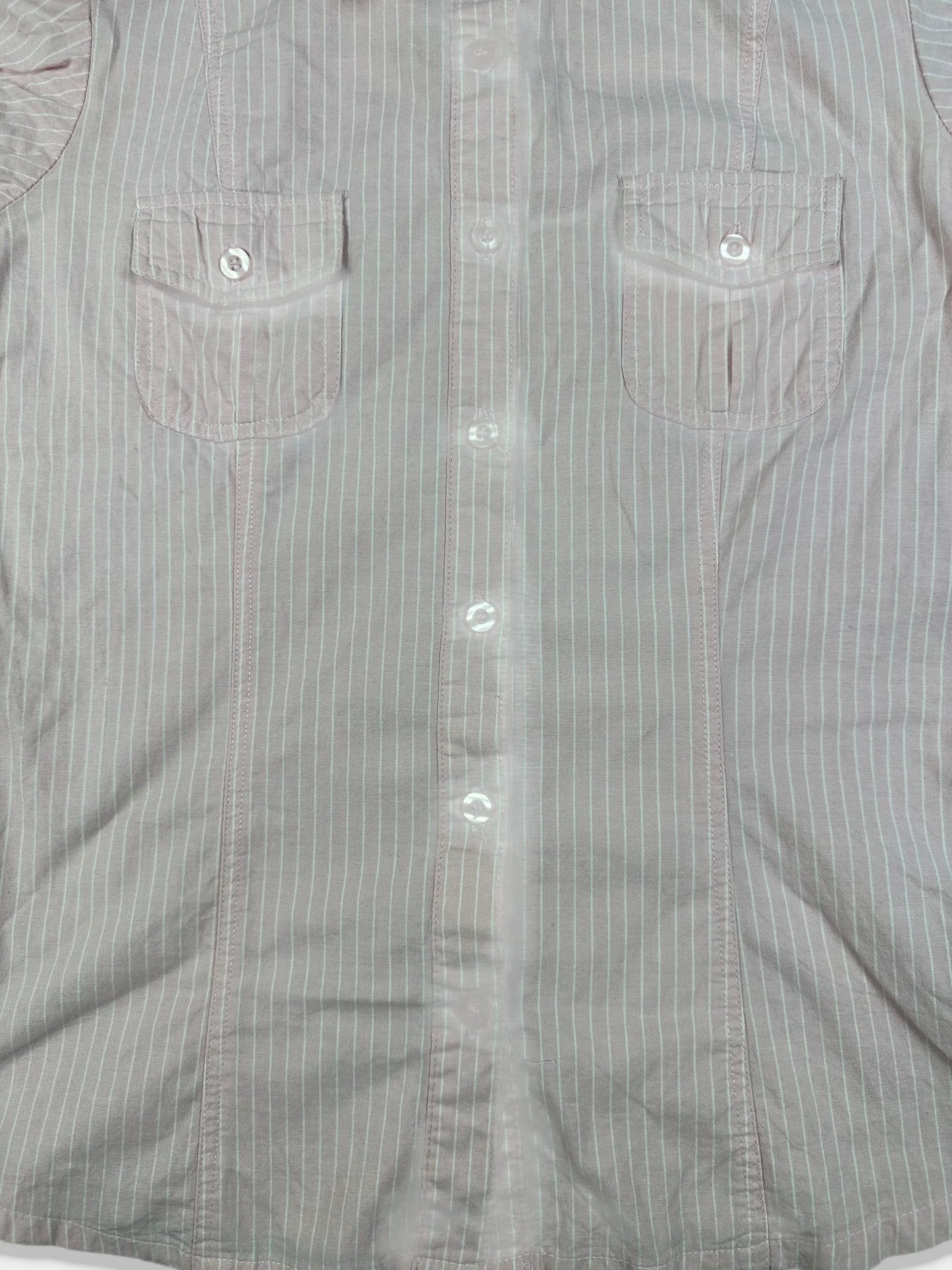Detail view of a short sleeve shirt in light gray with pinstripes and two front pockets.