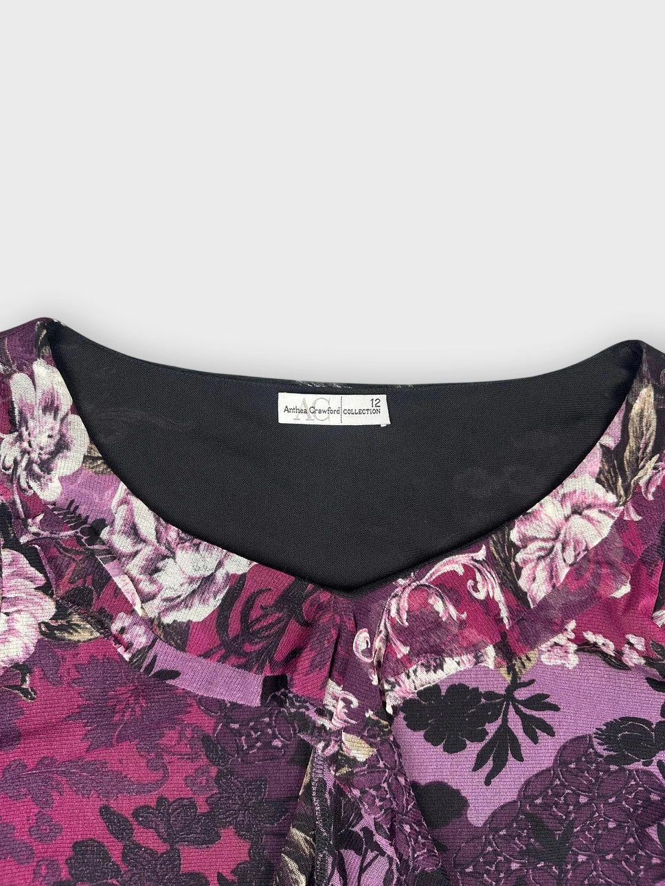 Purple floral lace top detail view showcasing ruffled neckline and sheen.