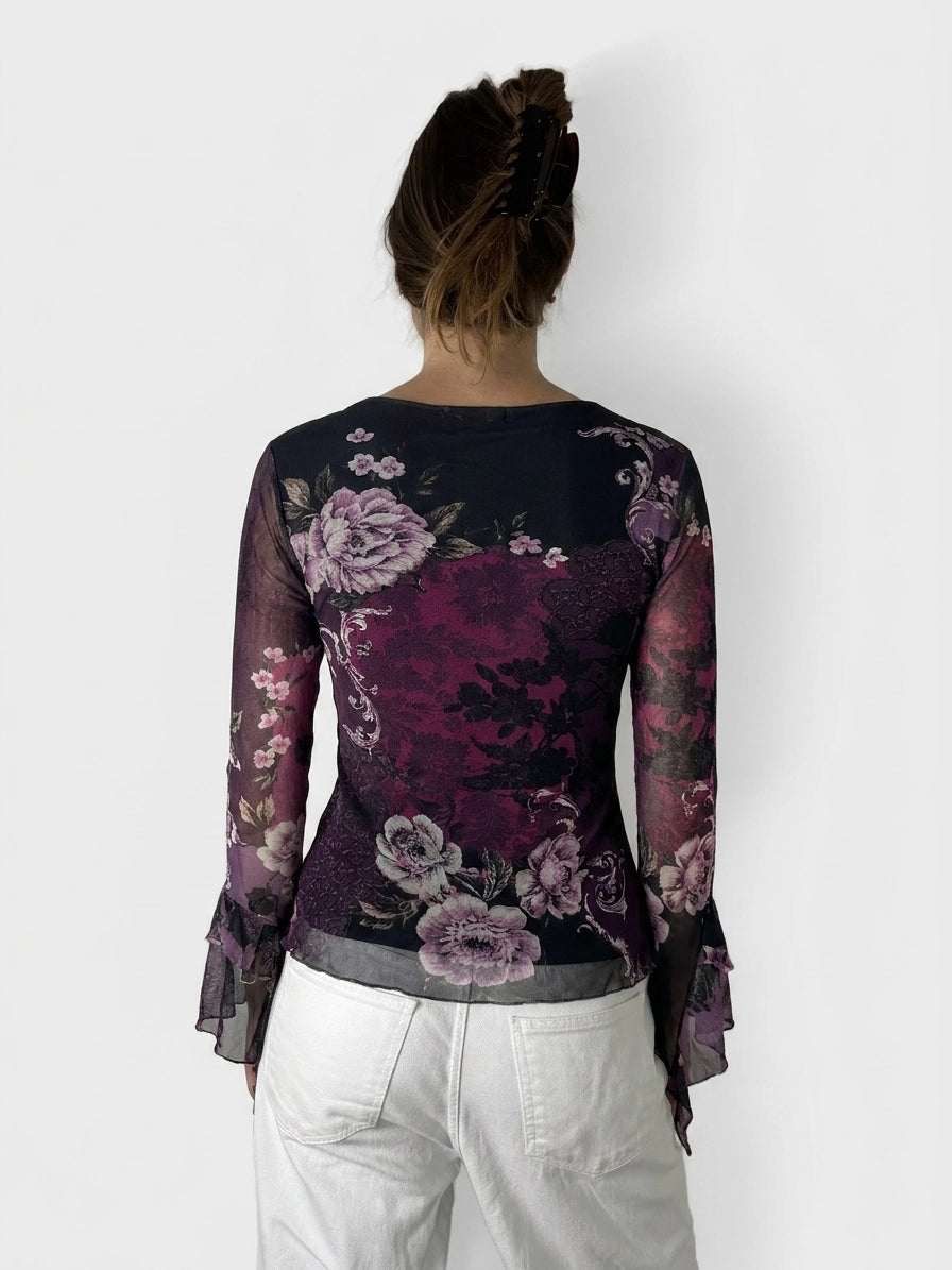 Back view of a purple floral lace top with bell sleeves.