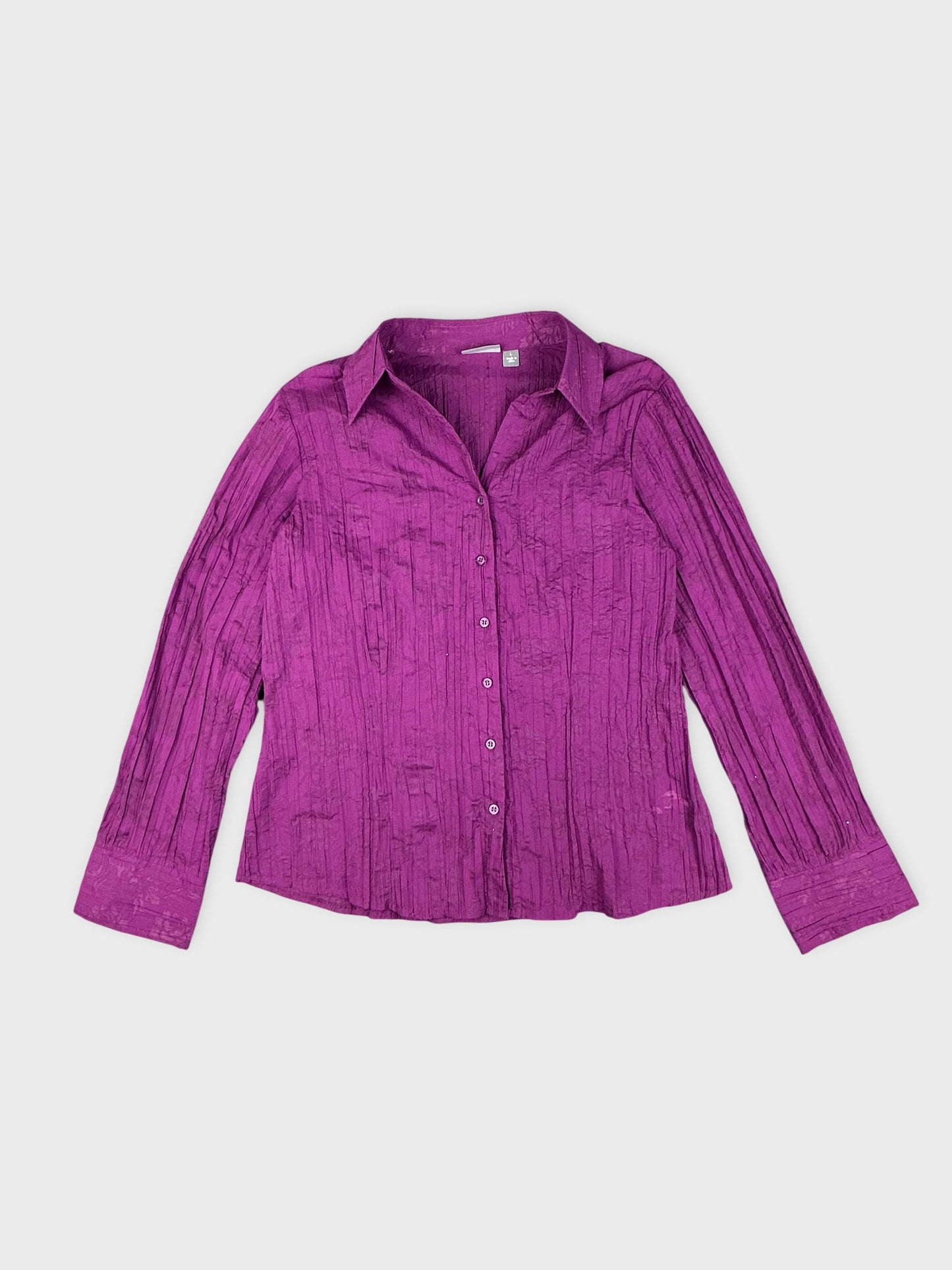 Detail view of a purple striped shirt featuring textured fabric and button closure.
