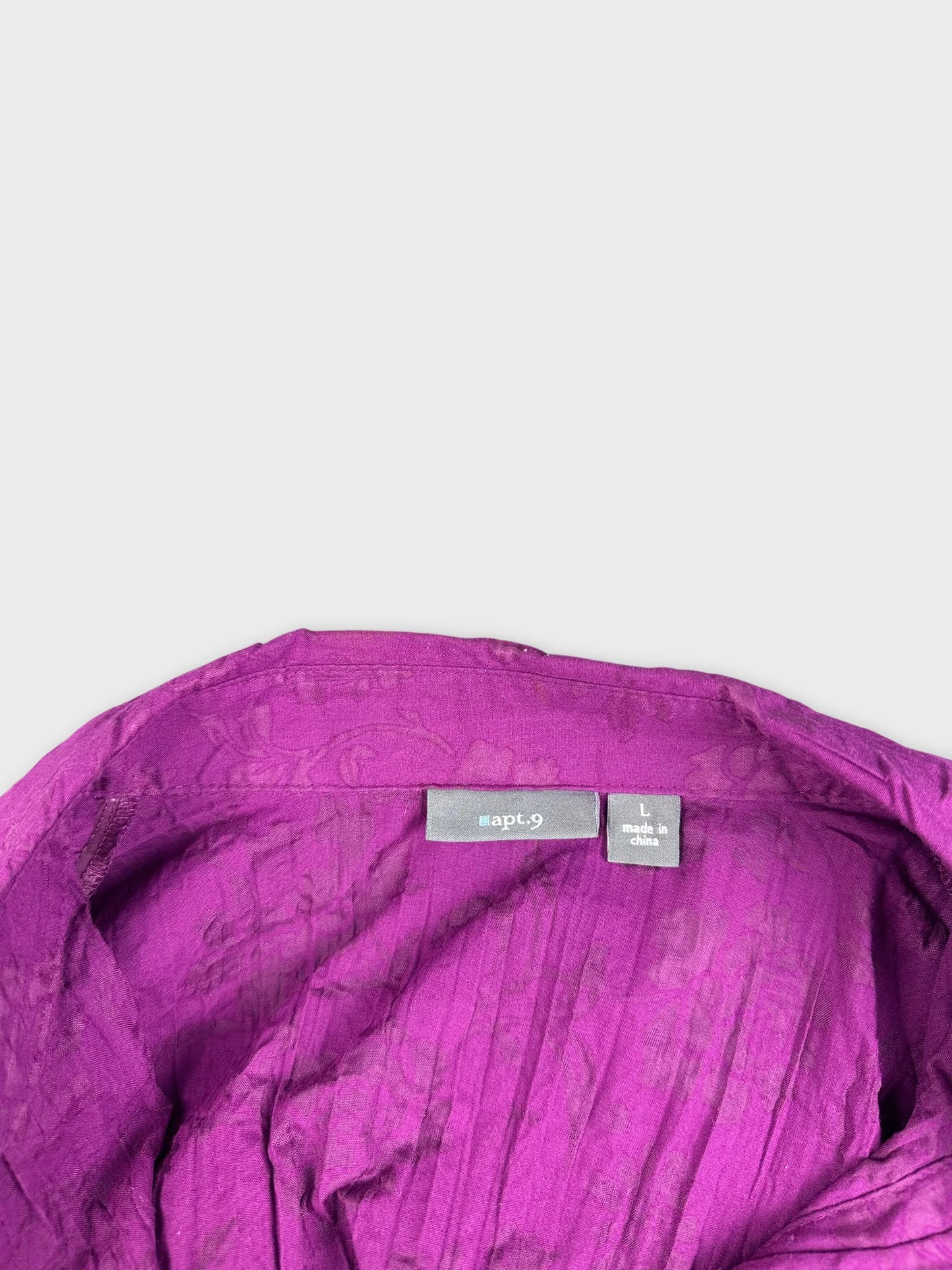 Detail view of a purple striped shirt with textured fabric.