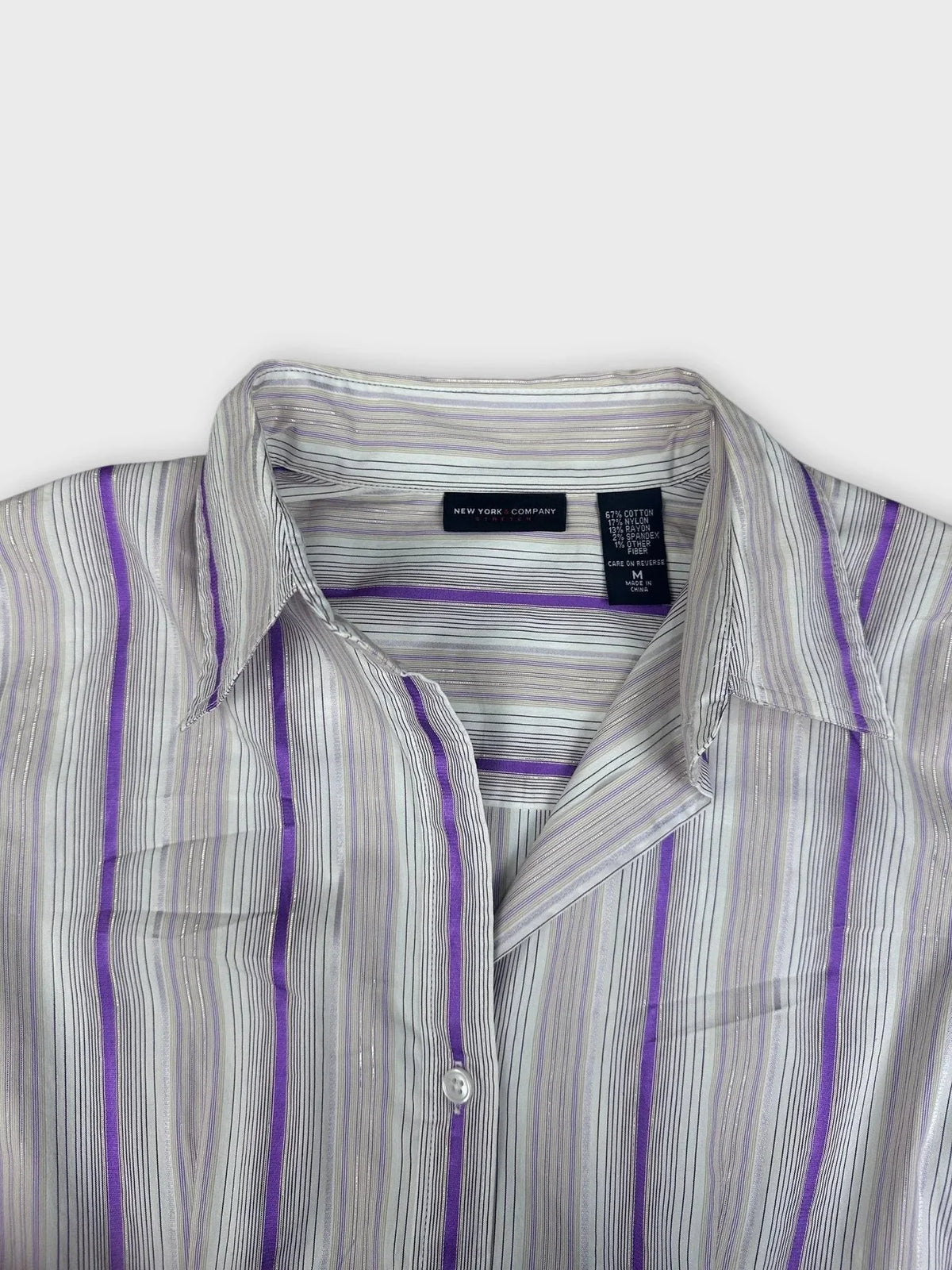 Detail view of a purple striped fitted blouse with sheen.