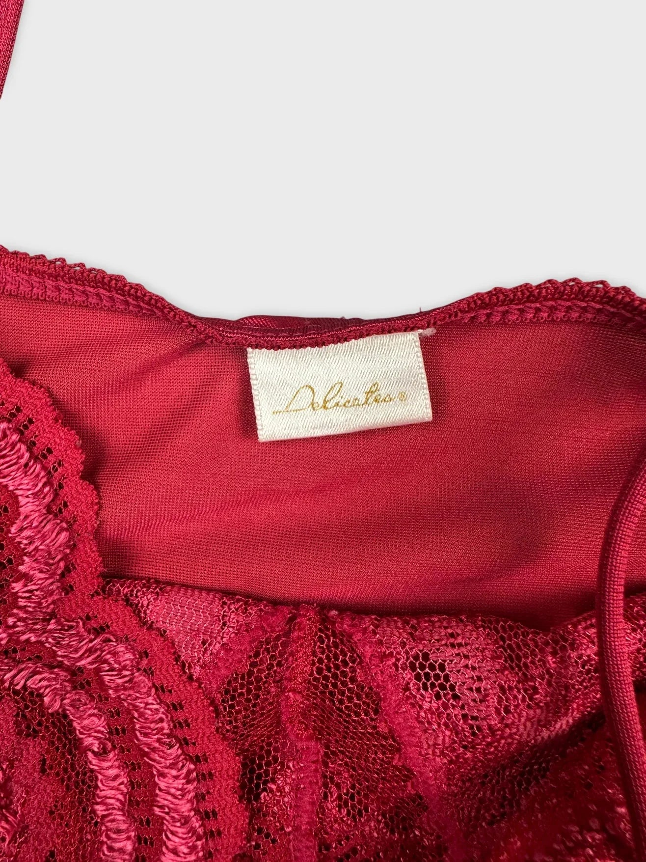 Detail view of a red lace slip dress with adjustable straps.
