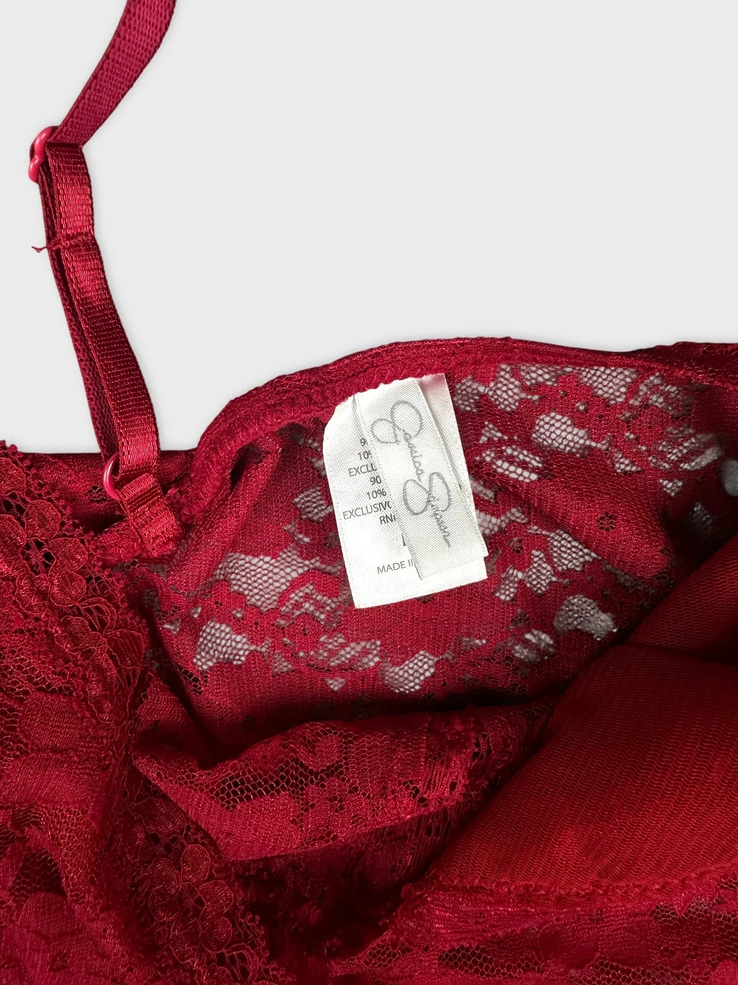 Detail view of red lace top with sheer design and intricate lace trim.