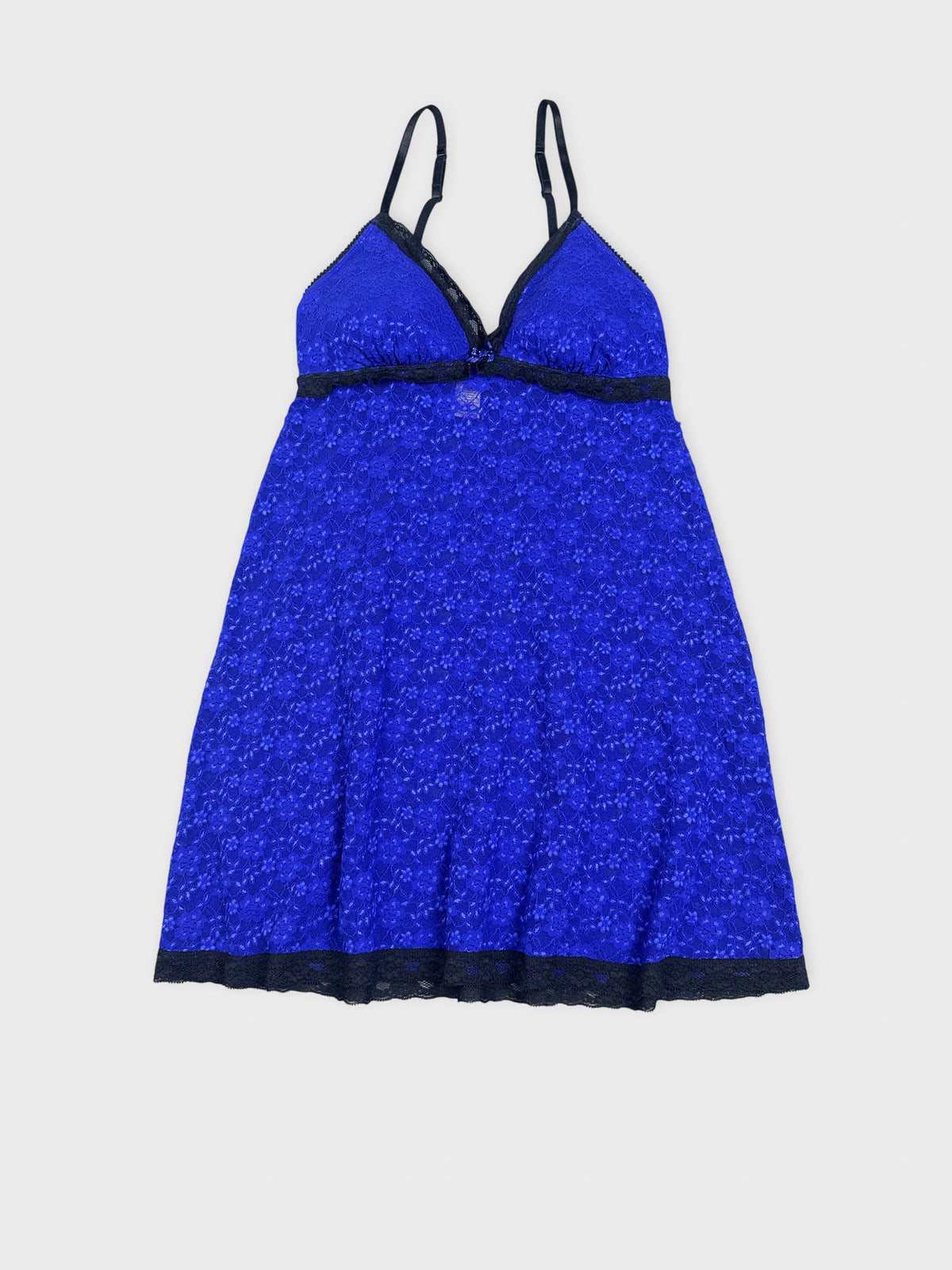 Detail view of a royal blue mini dress with black lace trim.