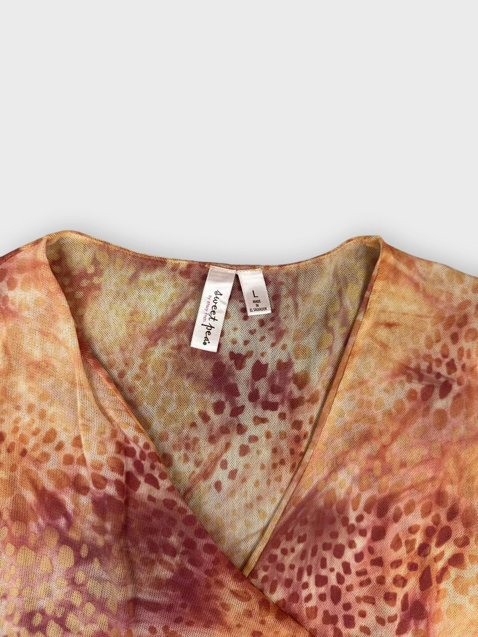 detail view of rust tie-dye ruched top with a v-neckline