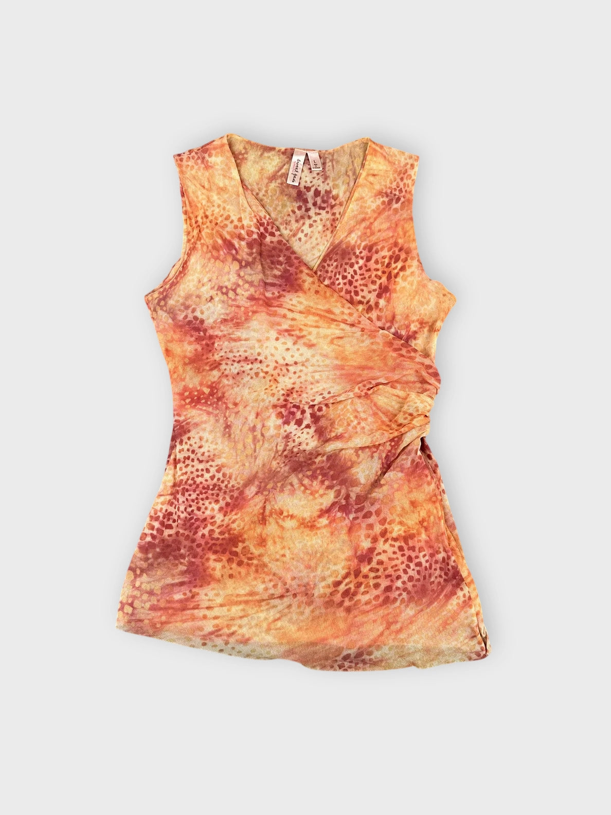 Front view of a rust tie-dye ruched sleeveless top with wrap design.