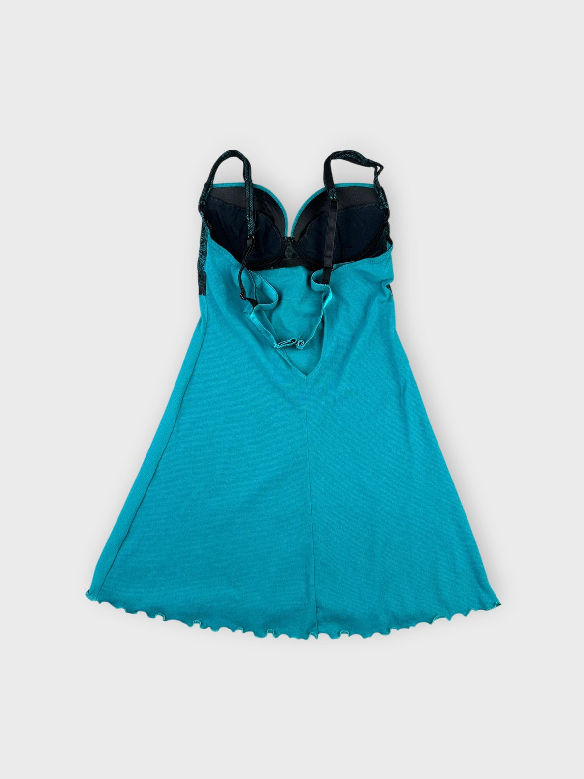 Back view of sheer aqua lace top with scalloped hem and black overlay.