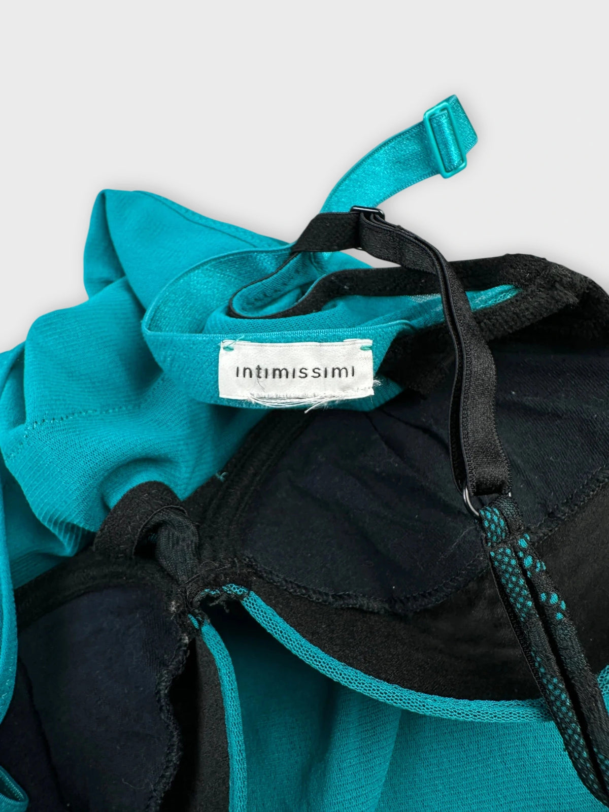 Sheer aqua lace top detail view showing scalloped hem and strap