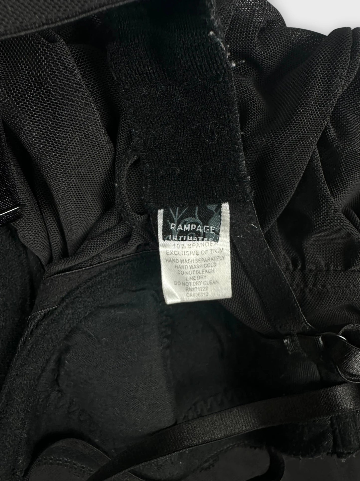 Detail view of sheer black babydoll top with pink trim and straps.