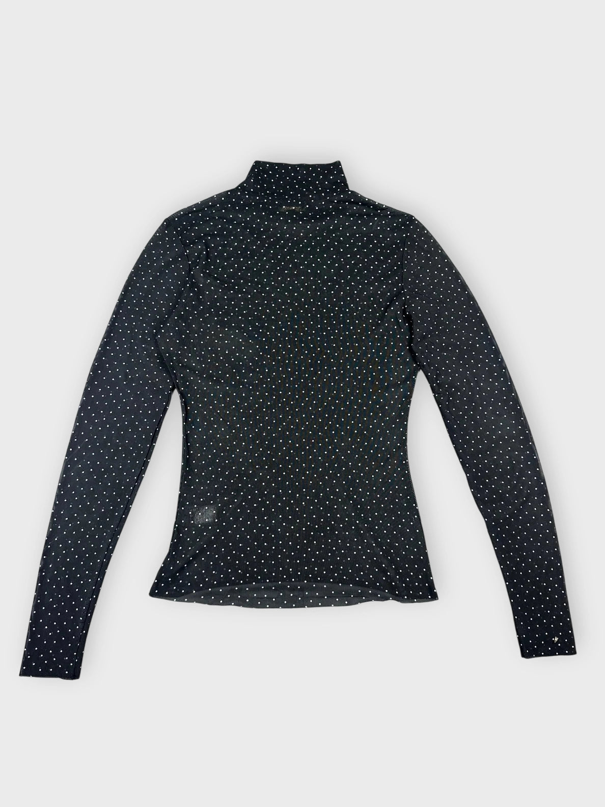 Back view of a sheer black long sleeve top with polka dots.