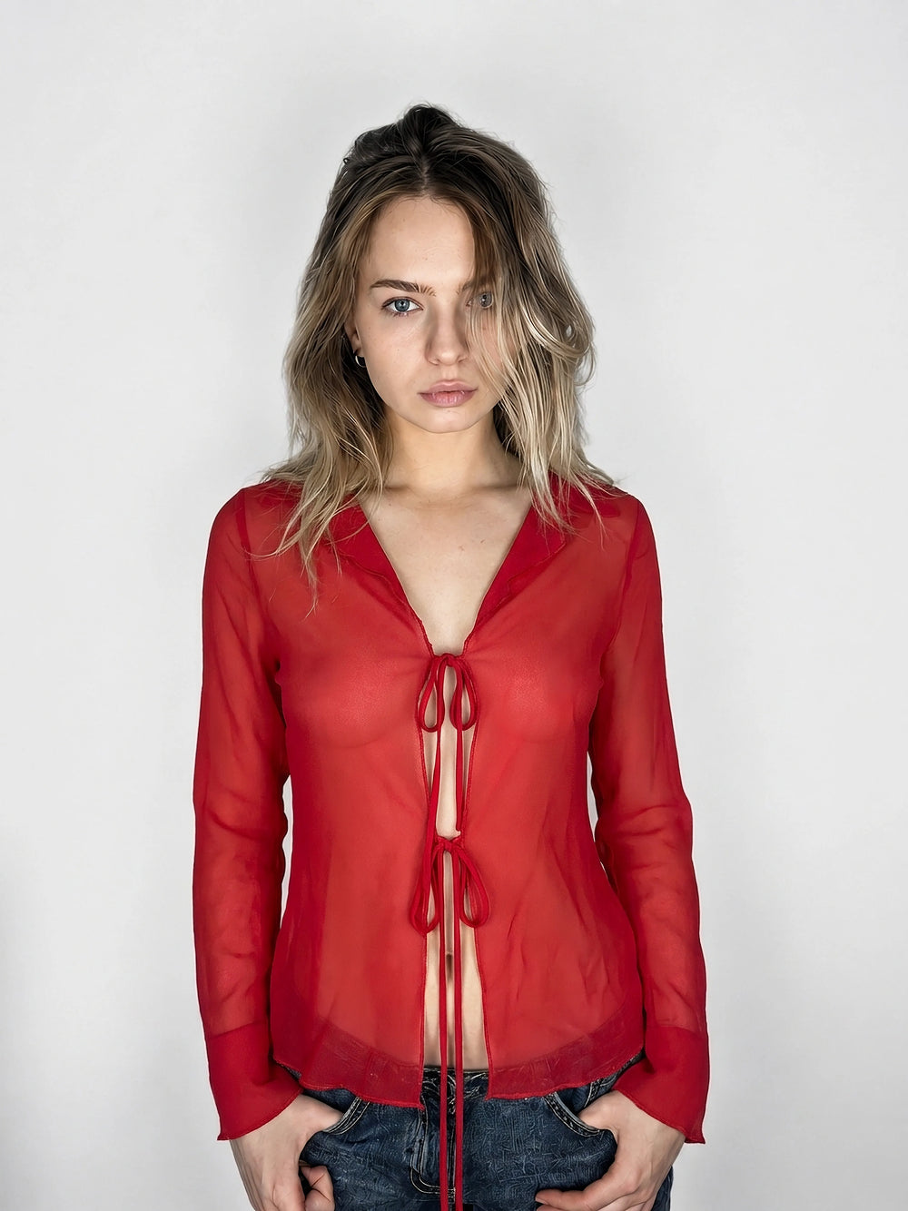 Front view of a sheer red button-up top with tie detail.