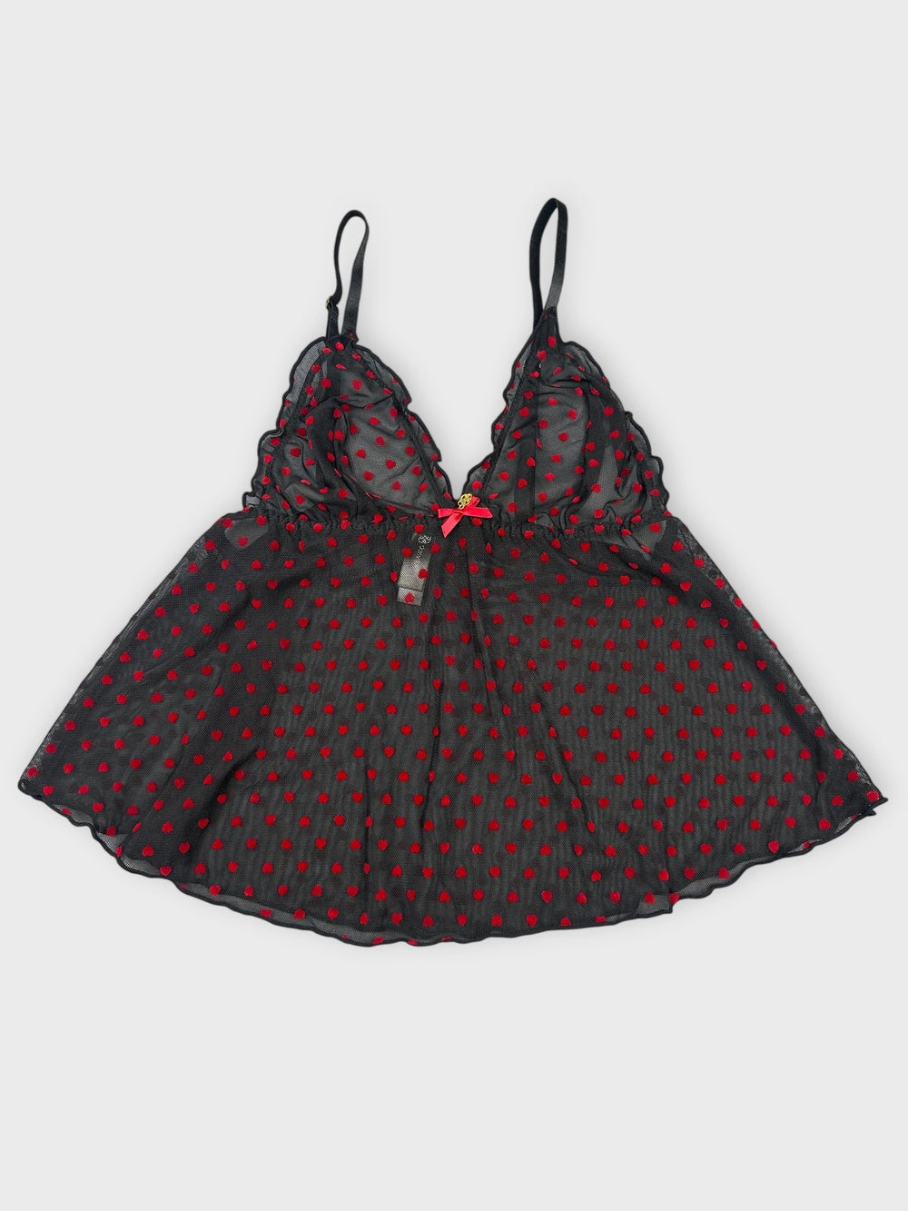 Front view of sheer black camisole with red polka dots and lace trim.
