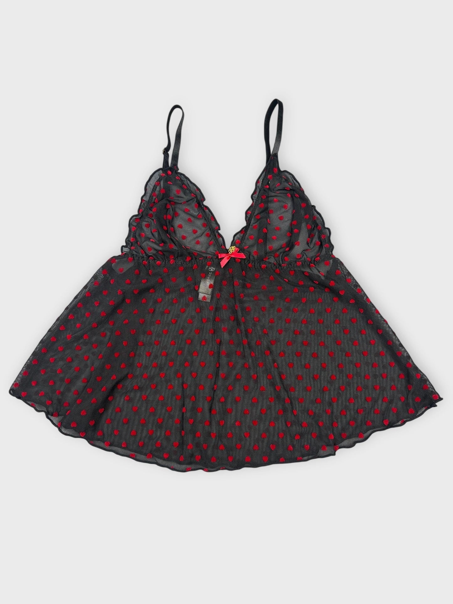 Front view of sheer black camisole with red polka dots and lace trim.