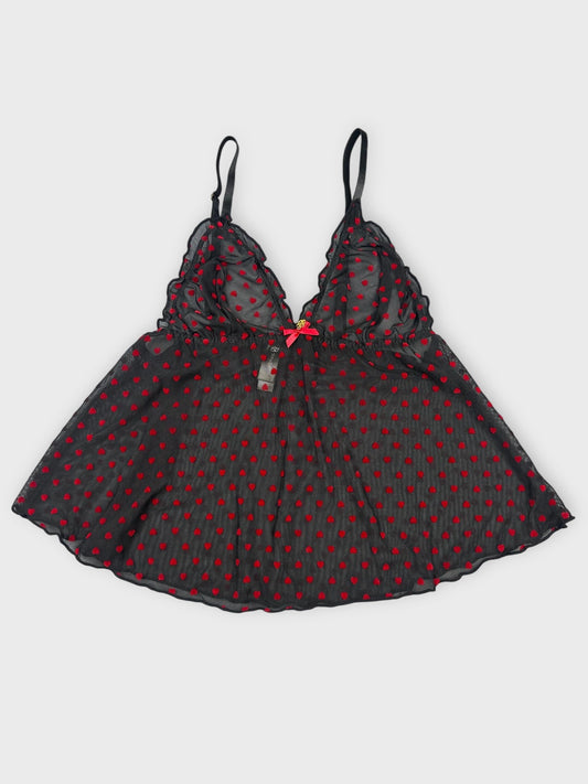 Front view of sheer black camisole with red polka dots and lace trim.