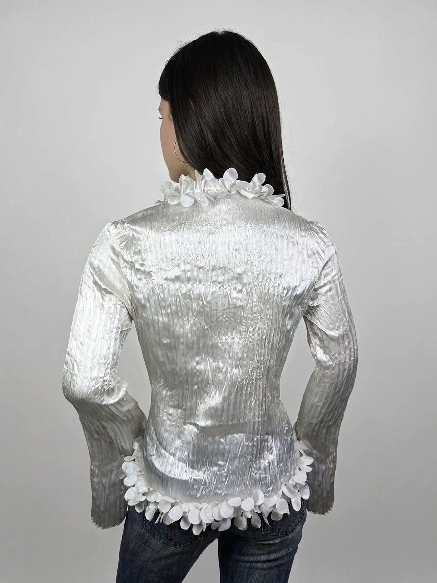 Back view of shiny white long sleeve blouse with floral trim.