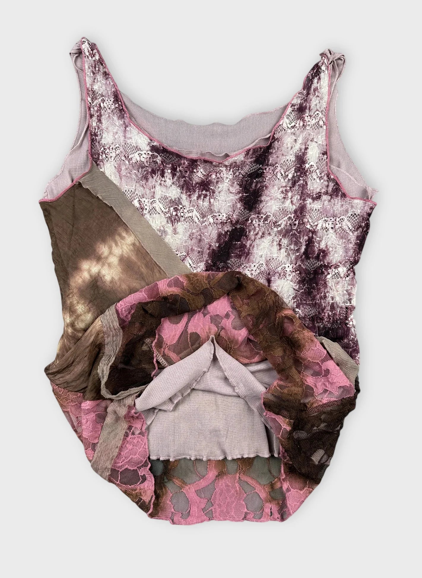 Detail view of a silk layered tank top in chocolate pink featuring lace elements.
