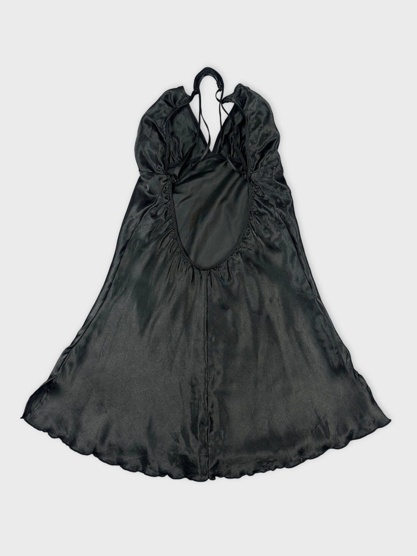 Back view of a silky black halter top with adjustable straps and flowing design.