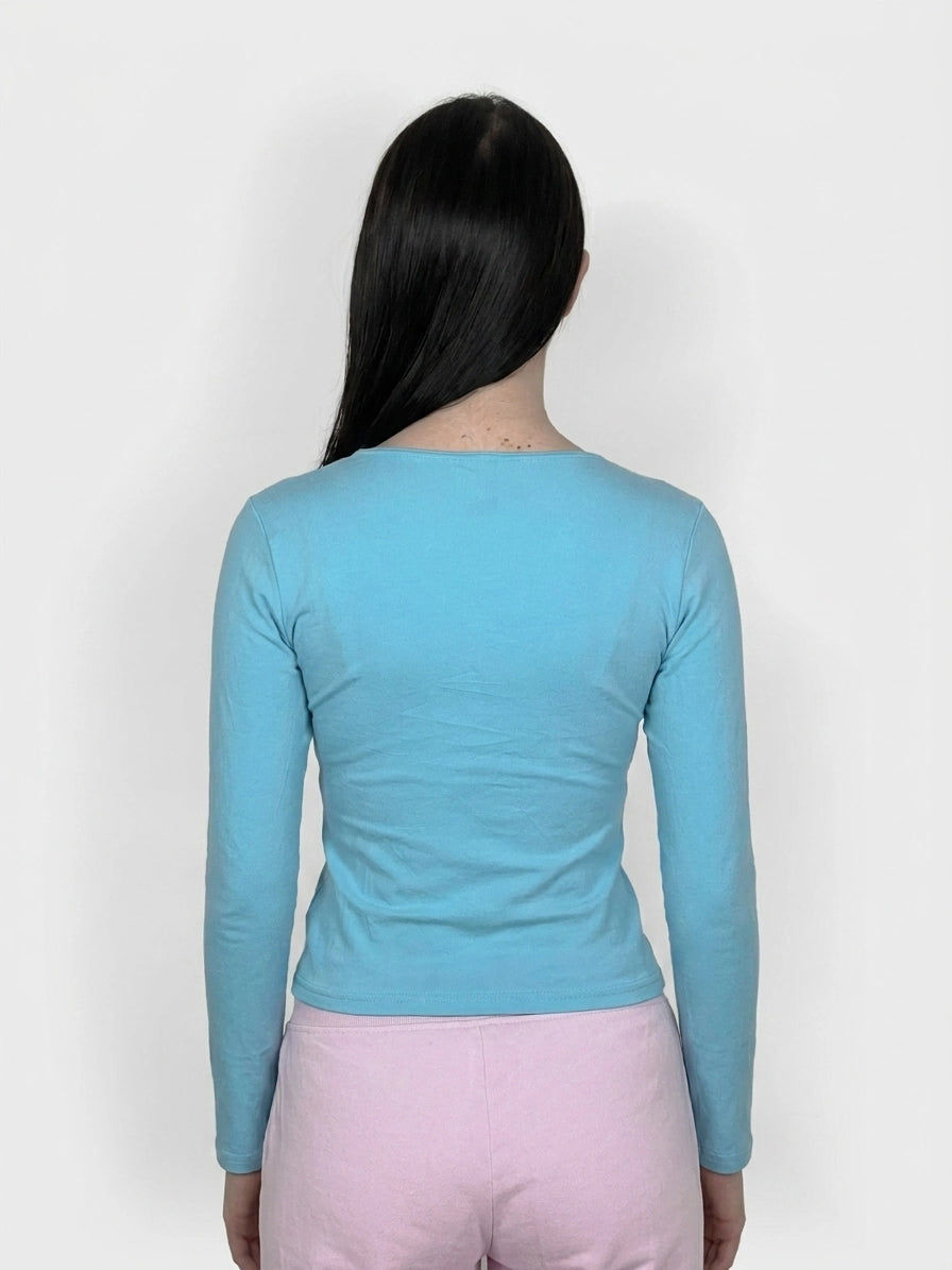Sky blue long sleeve top with a fitted shape, back view.