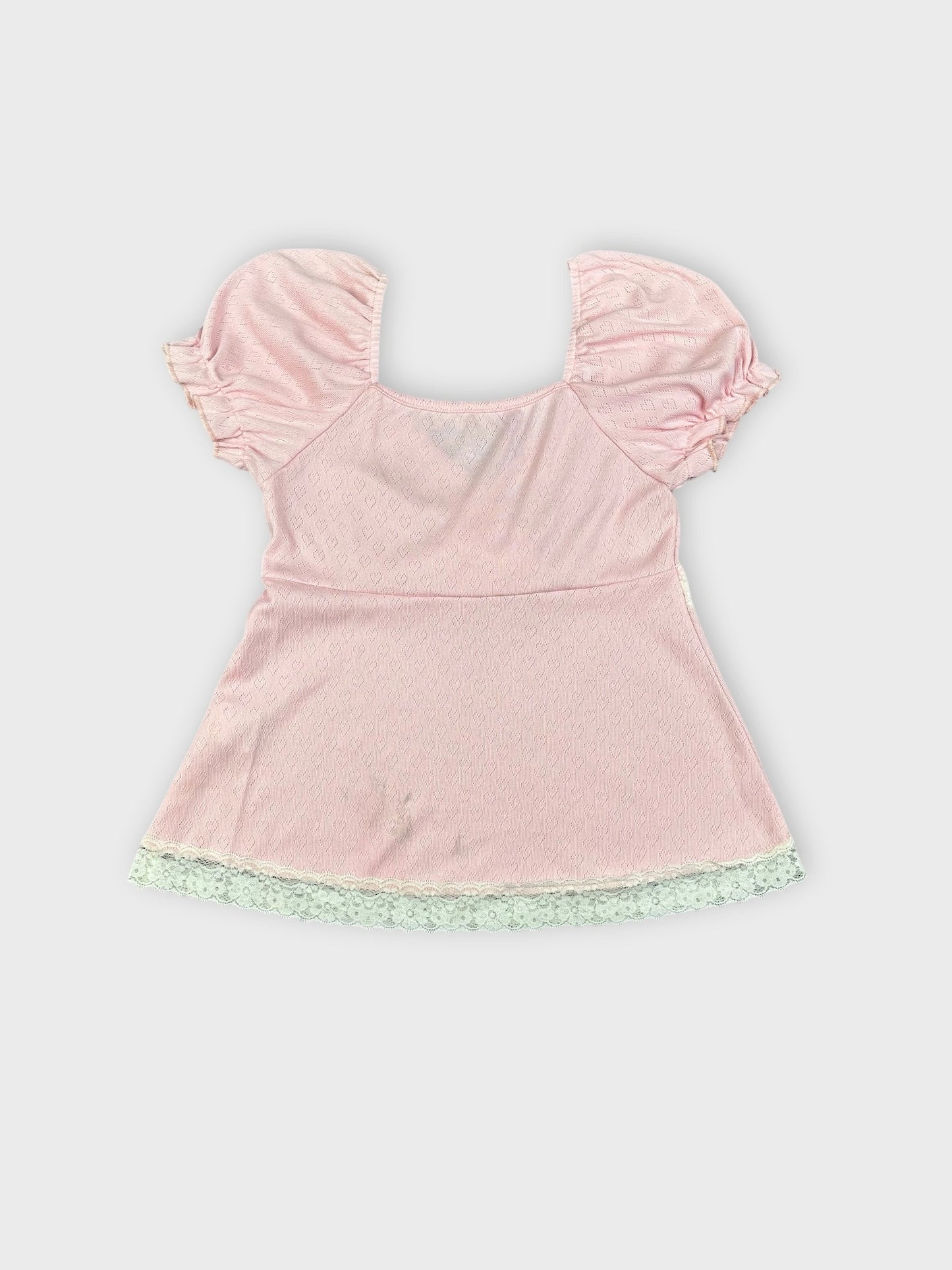 Back view of soft pink blouse with lace trim and puff sleeves