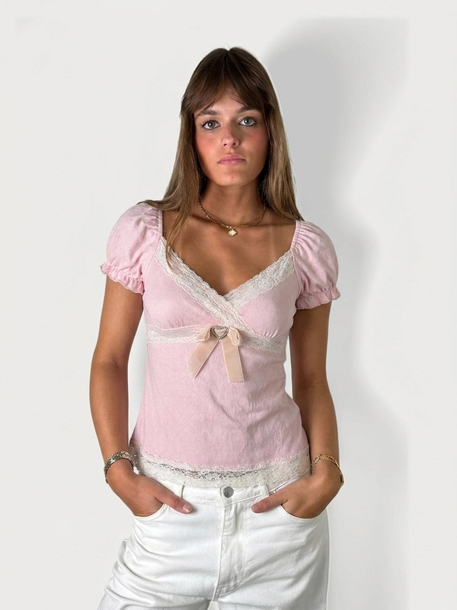 Soft pink lace-trim blouse with bow, front view, featuring puff sleeves.