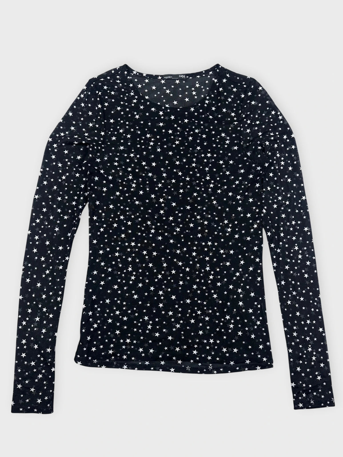 Detail view of a black long sleeve top with a star print.