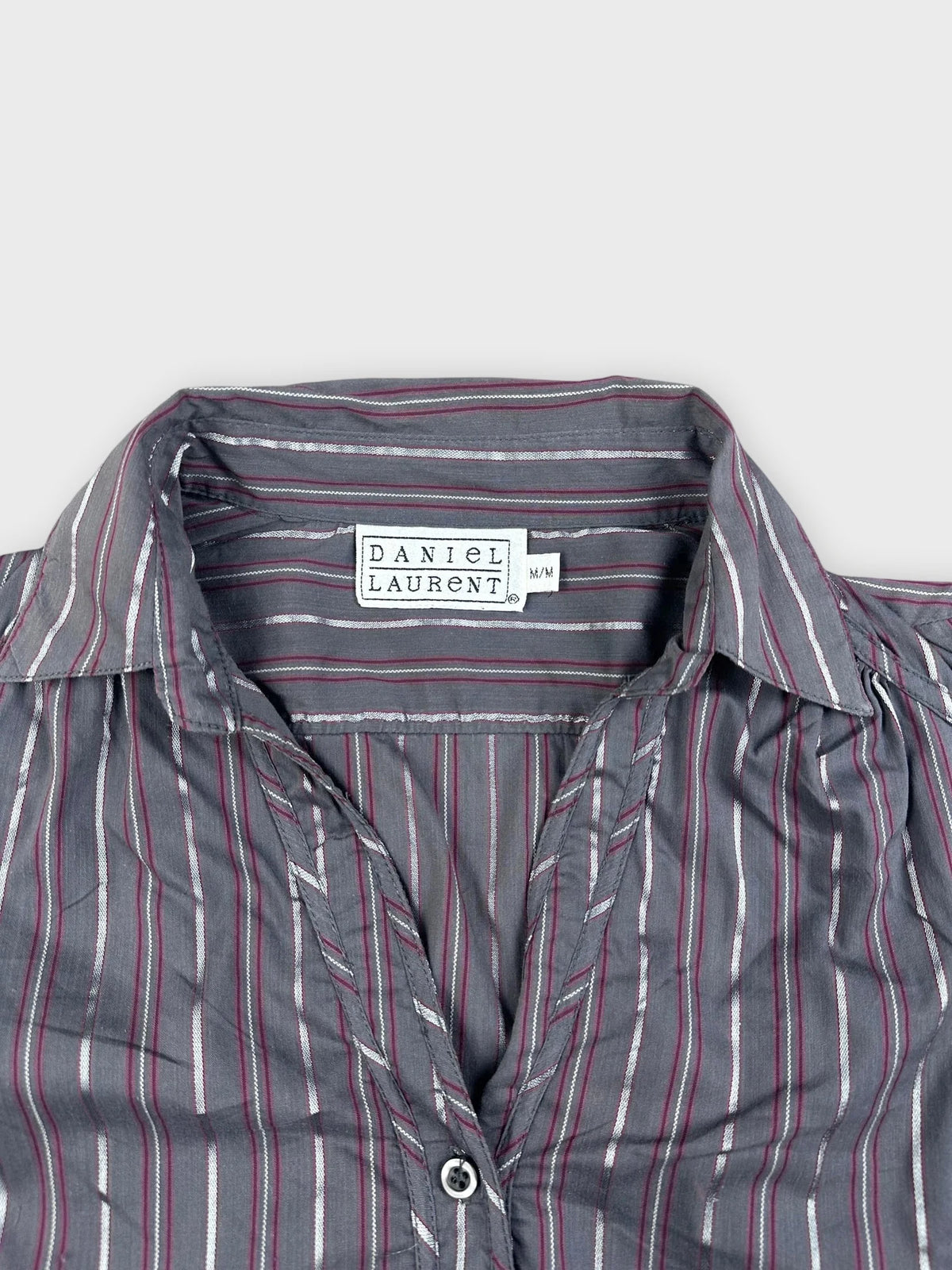 Detail view of a striped long sleeve button-up shirt in grey with contrasting stripes.