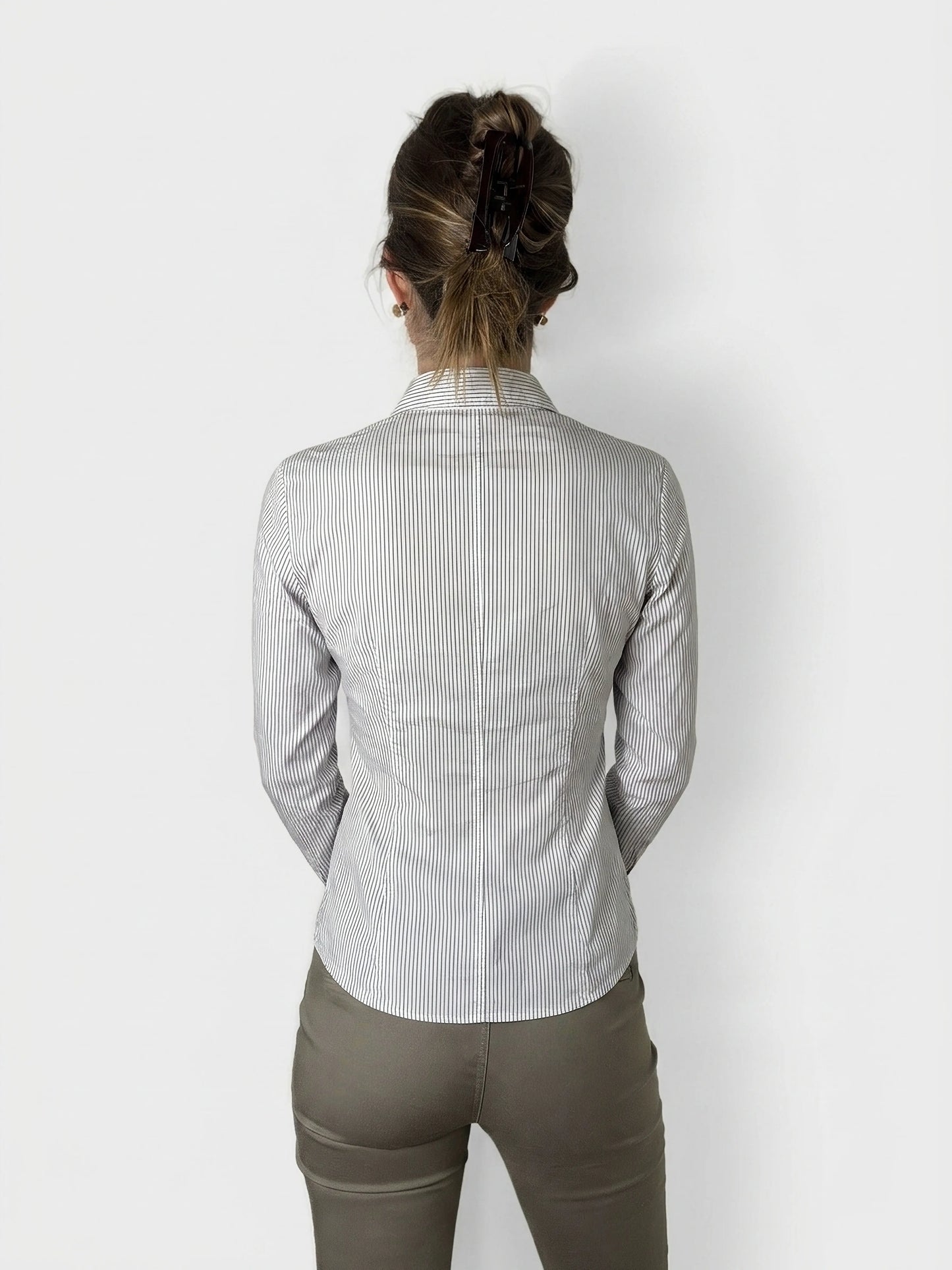 Back view of a striped button-up blouse with ruffle detail.