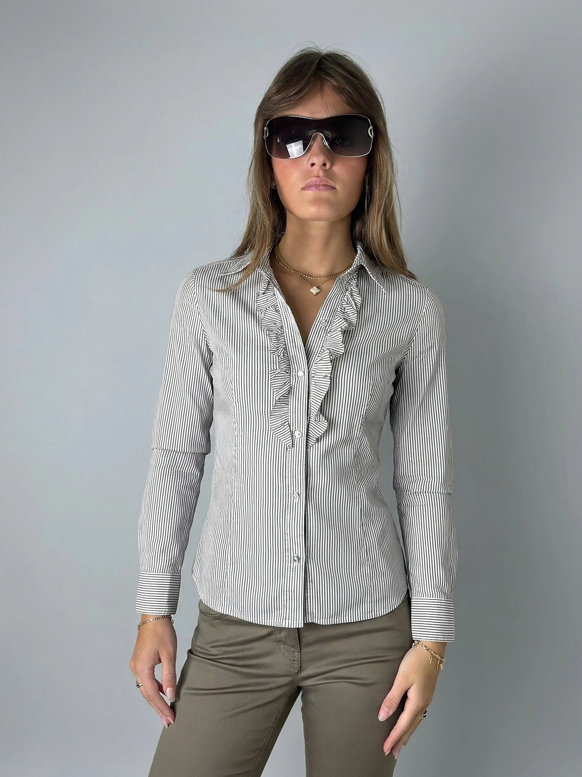 Front view of a striped button-up shirt with ruffle detail in black and white.