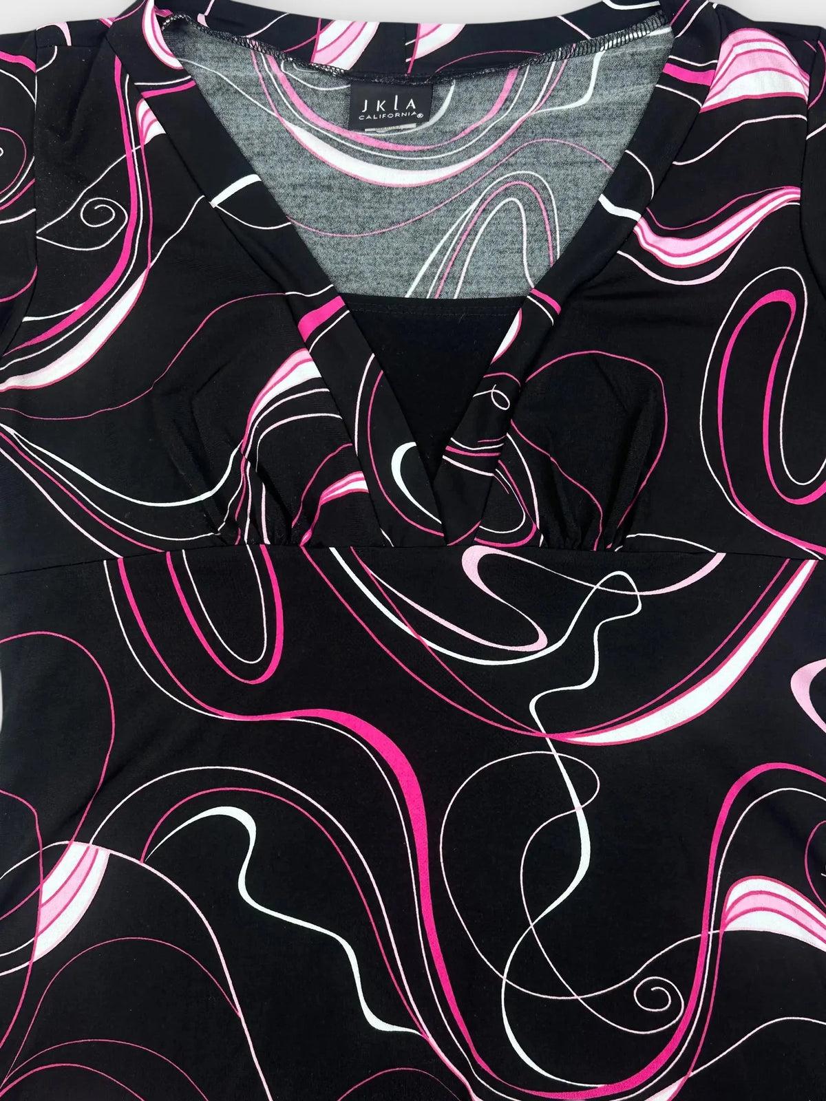 Detail view of black top featuring swirled pink and white graphic pattern.