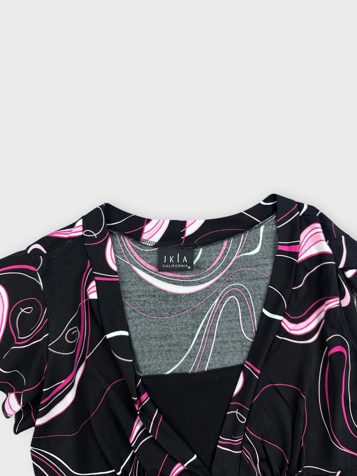 Detail view of black swirled graphic top with pink and white patterns.