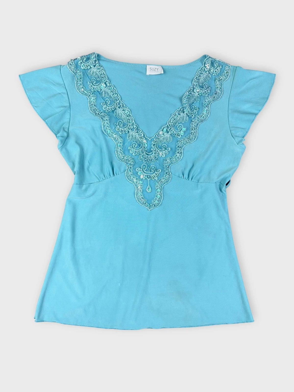 Front view of a turquoise short sleeve top with embroidered V-neckline.