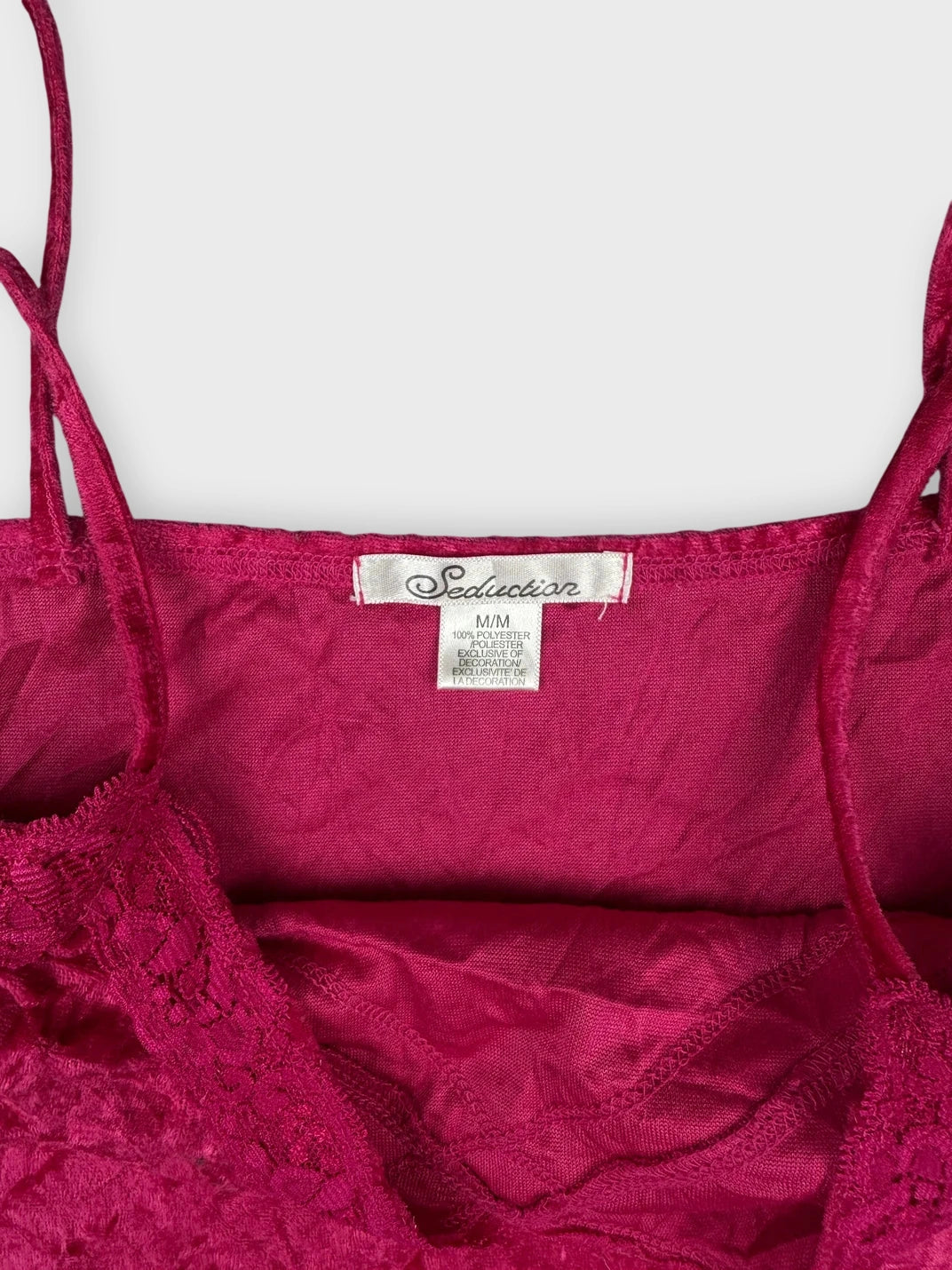 Detail view of vibrant fuchsia lace camisole with intricate lace trim.