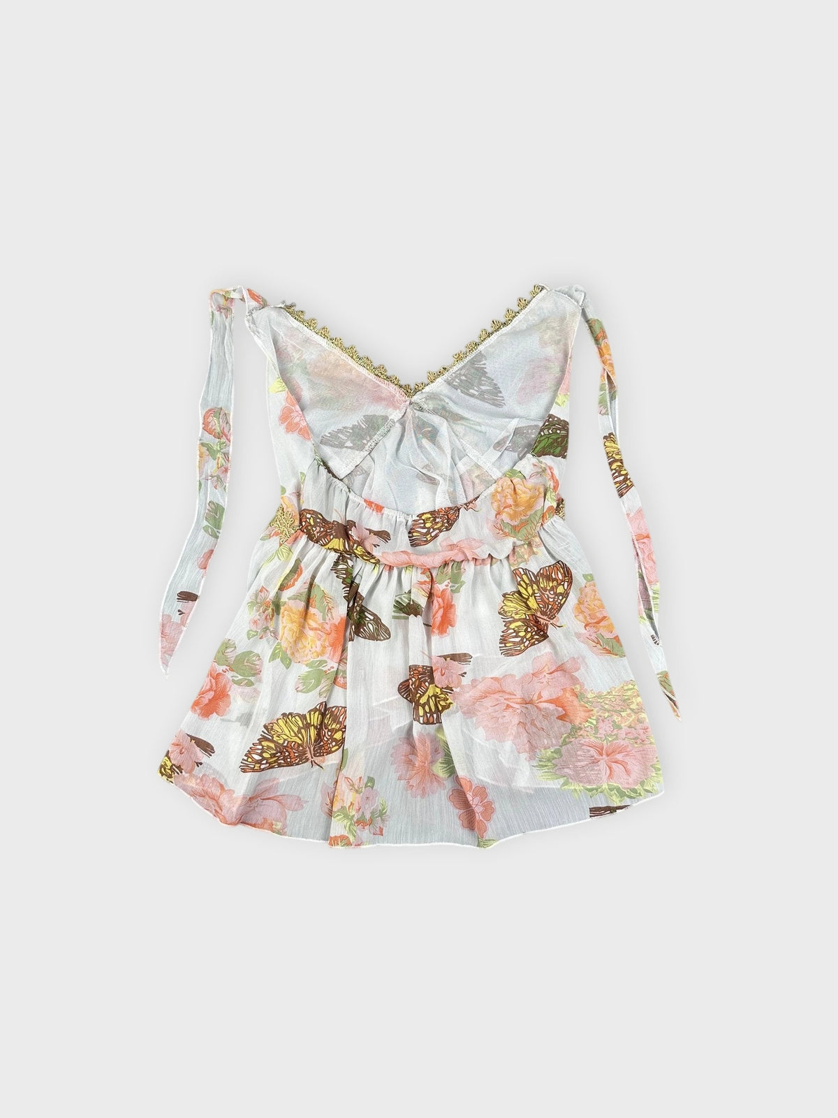 Back view of a vintage floral butterfly cami in white with ruffled trim.