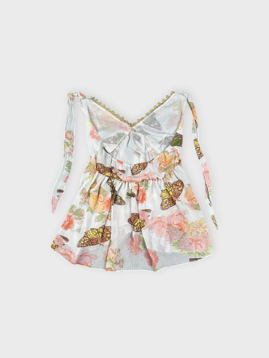 Back view of a vintage floral butterfly cami in white with ruffled trim.