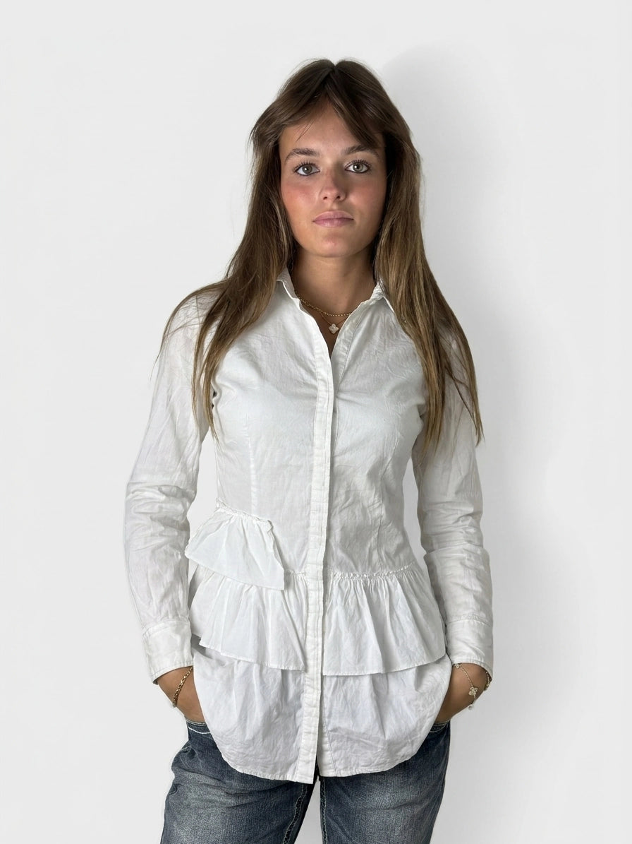Front view of a white cotton peplum button-up shirt featuring layered trim.