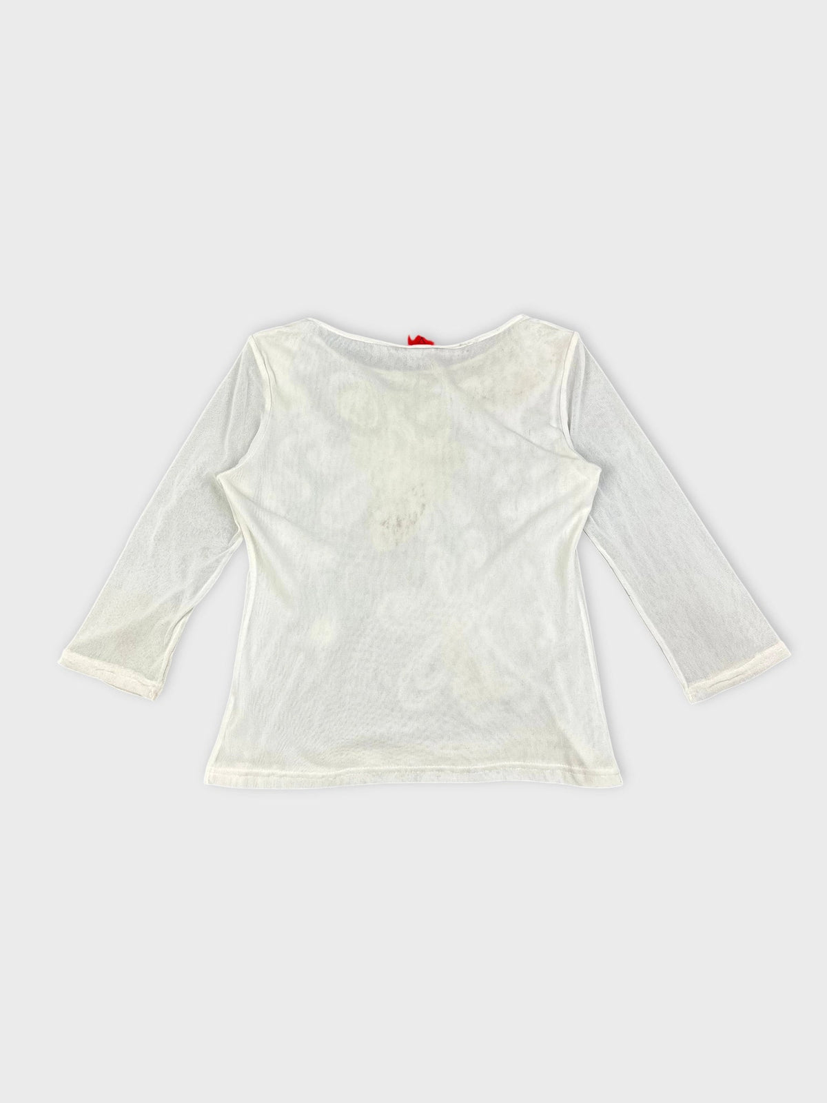 Back view of a white long sleeve top with floral embellishments.