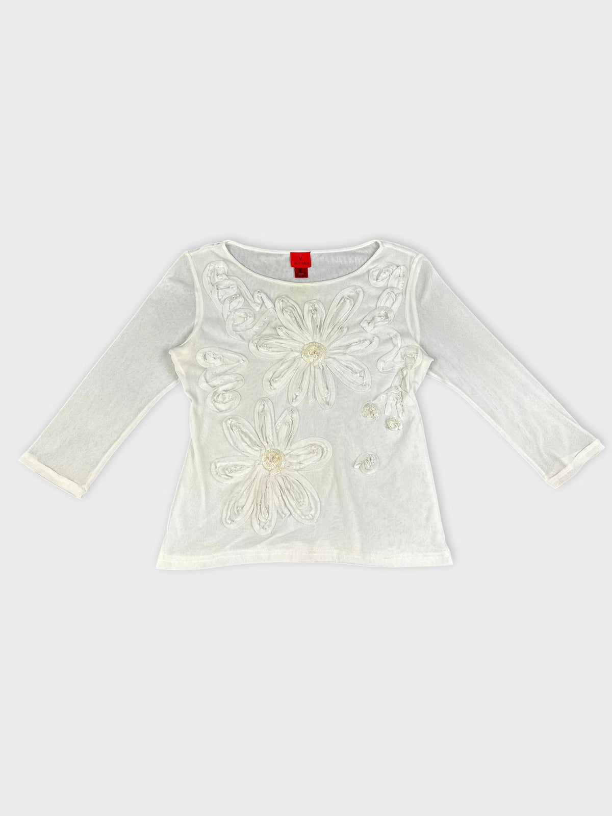 Front view of a white long sleeve top with floral embellishments.