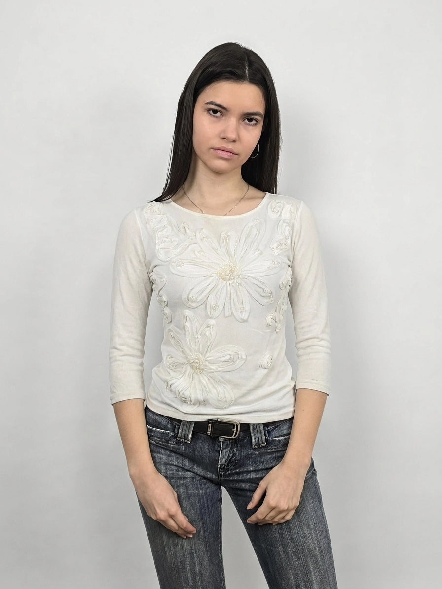 White long sleeve top with floral embellishments, front view.
