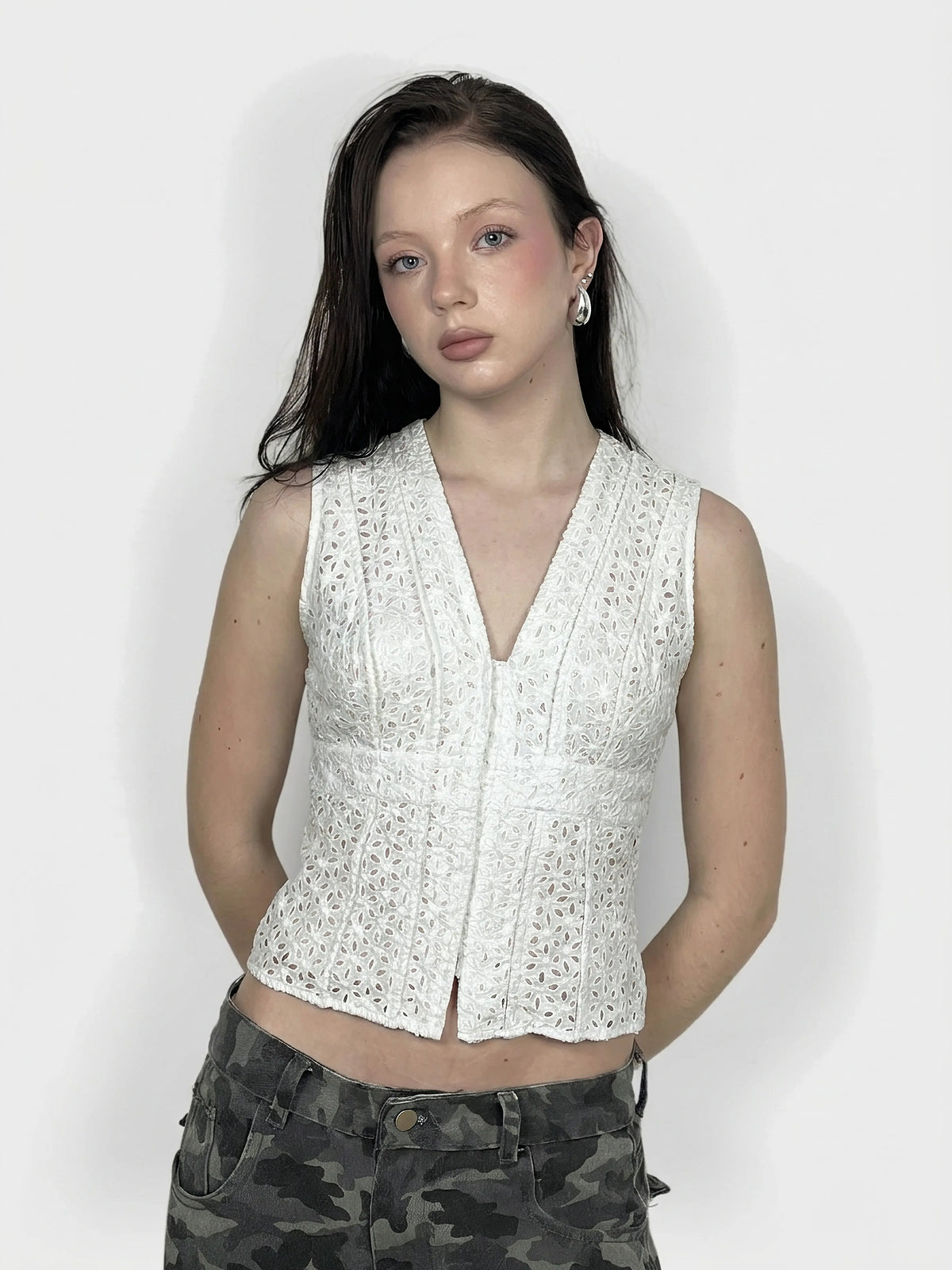 Front view of a white lace crop top with a V-neck detail.