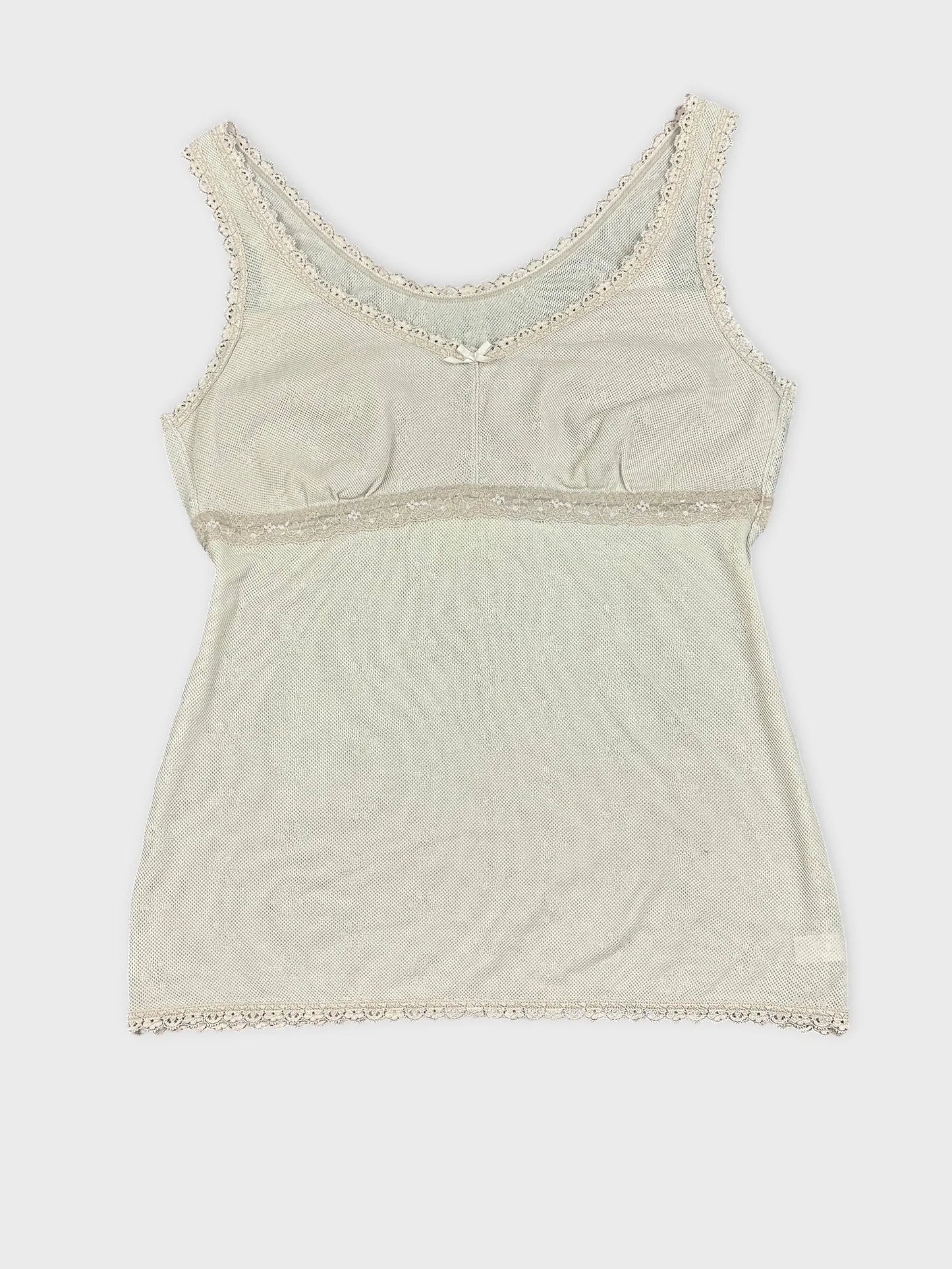 White lace-trimmed tank top with decorative bow detail view.
