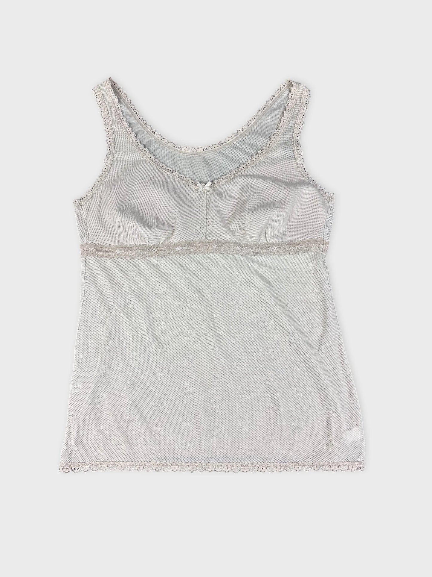 Detail view of a white lace-trimmed tank top with a delicate neckline.