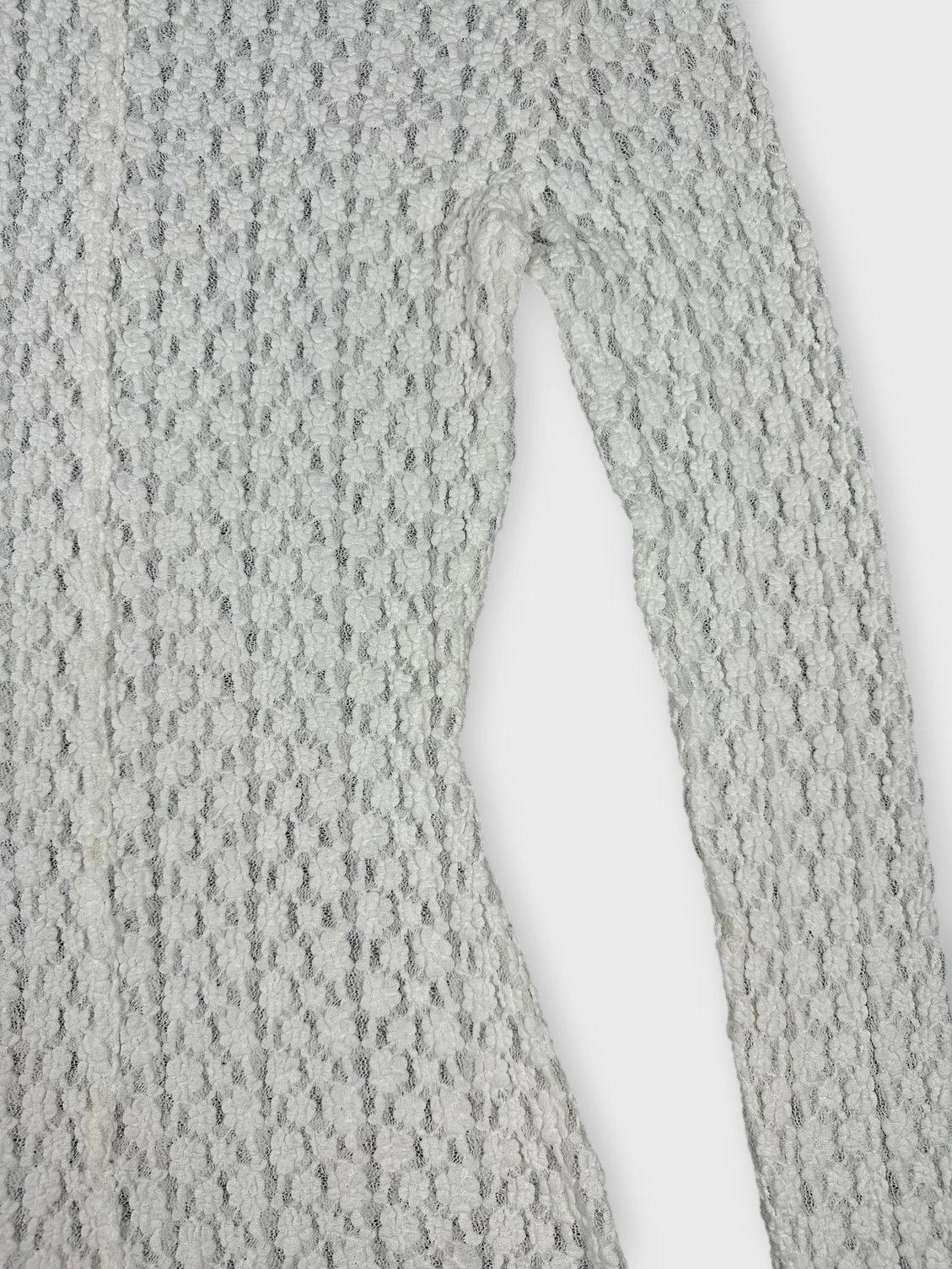 White sheer long sleeve blouse with textured pattern detail view.