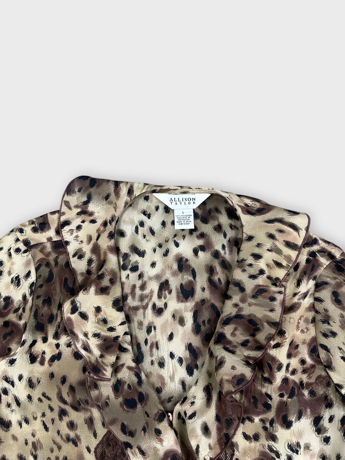 Detail view of a wild print wrap top in beige and brown with ruffles.
