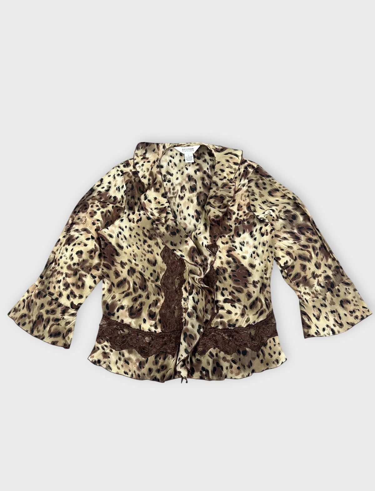 Detail view of wild print wrap top in beige and brown with ruffles