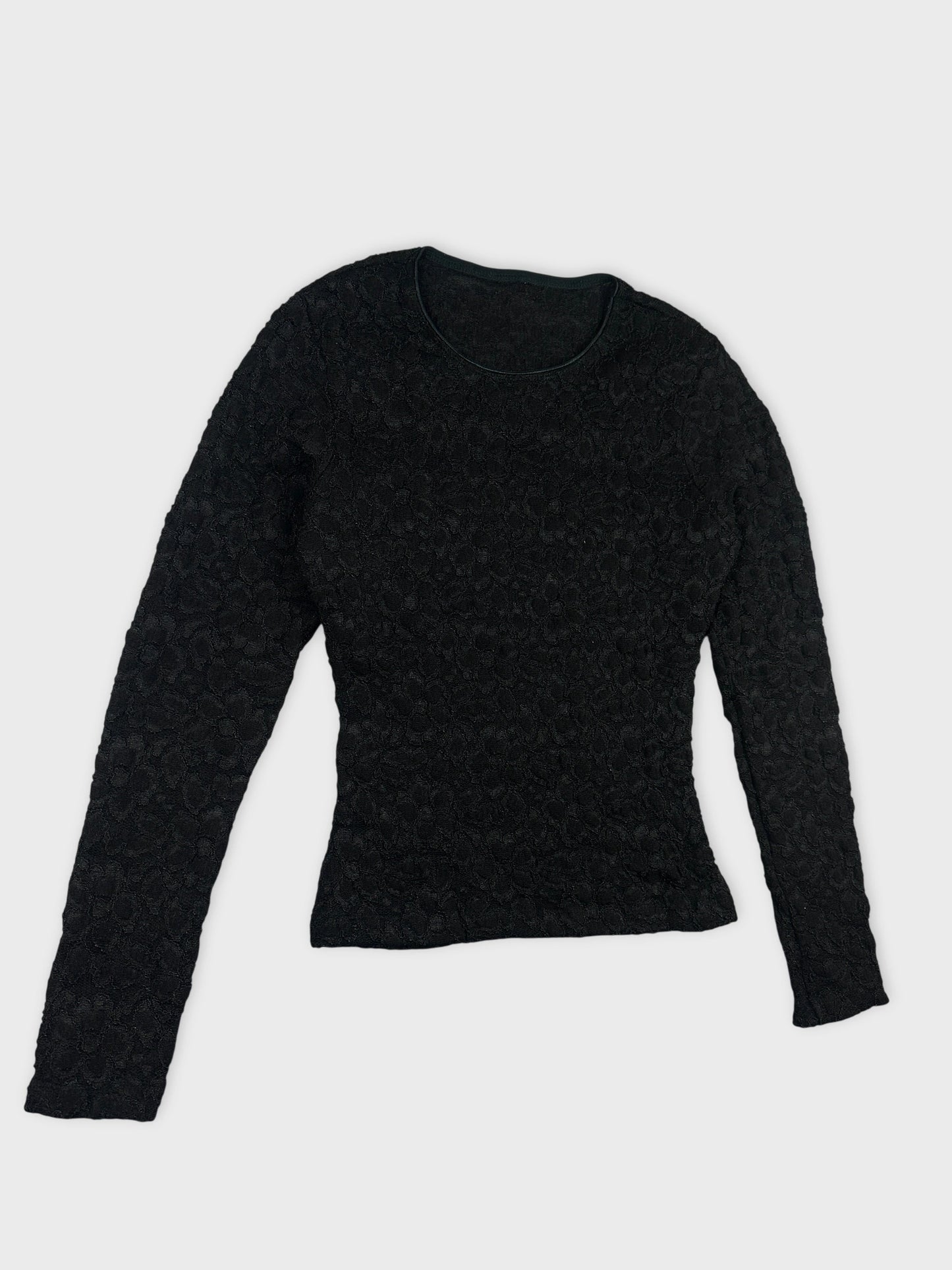 Detail view of a black body shirt with a textured floral pattern.