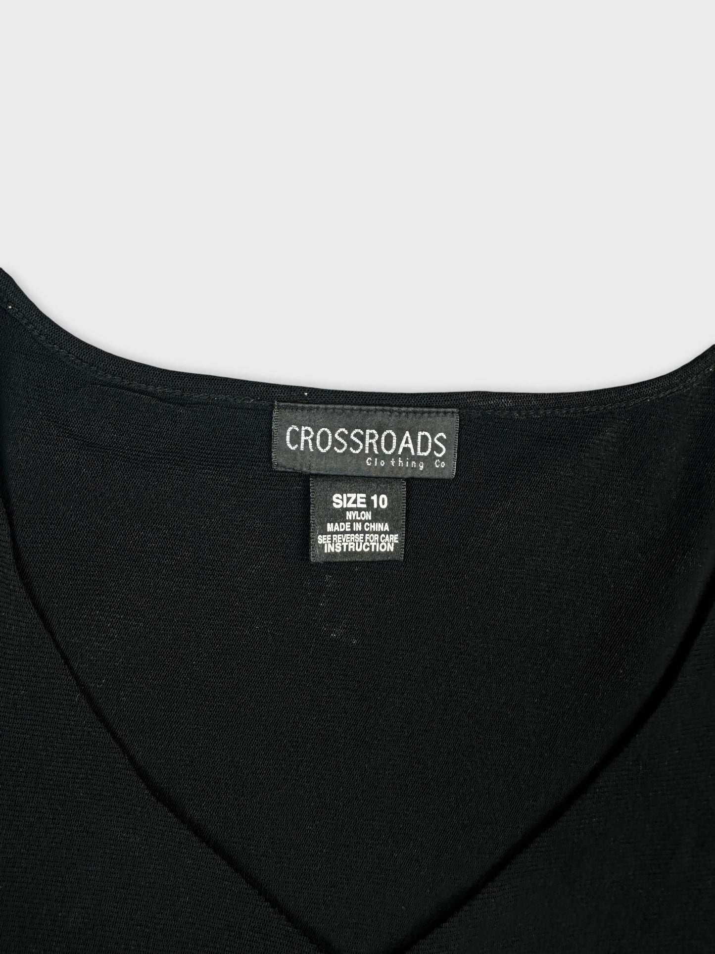 Detail view of a black body shirt featuring a v-neckline.