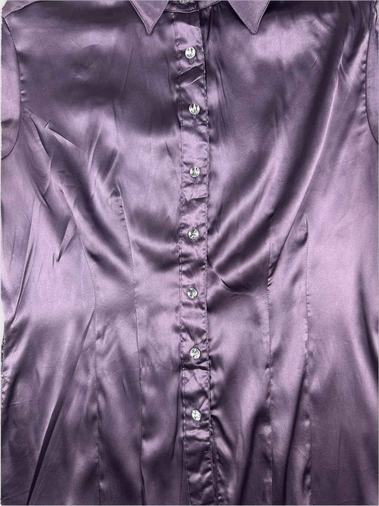 Detail view of a purple body shirt featuring a button-up front.